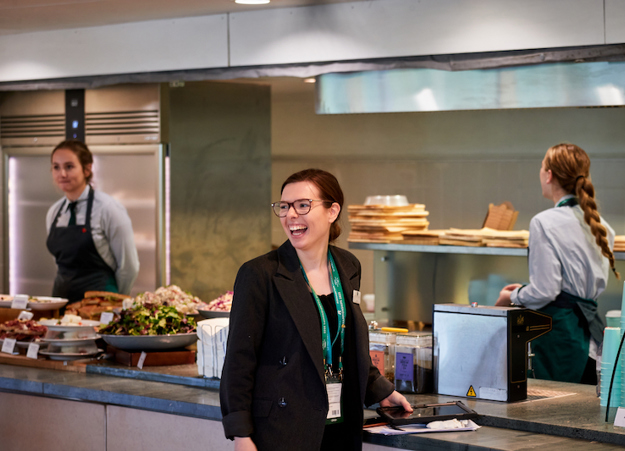 A female member of Constellation's leadership team laughing in a kitchen at Wimbledon.